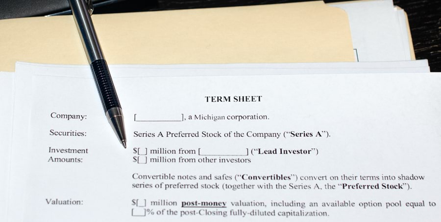A term sheet is shown on top of a manila folder with a zebra mechanical pen sitting on top of the paperwork
